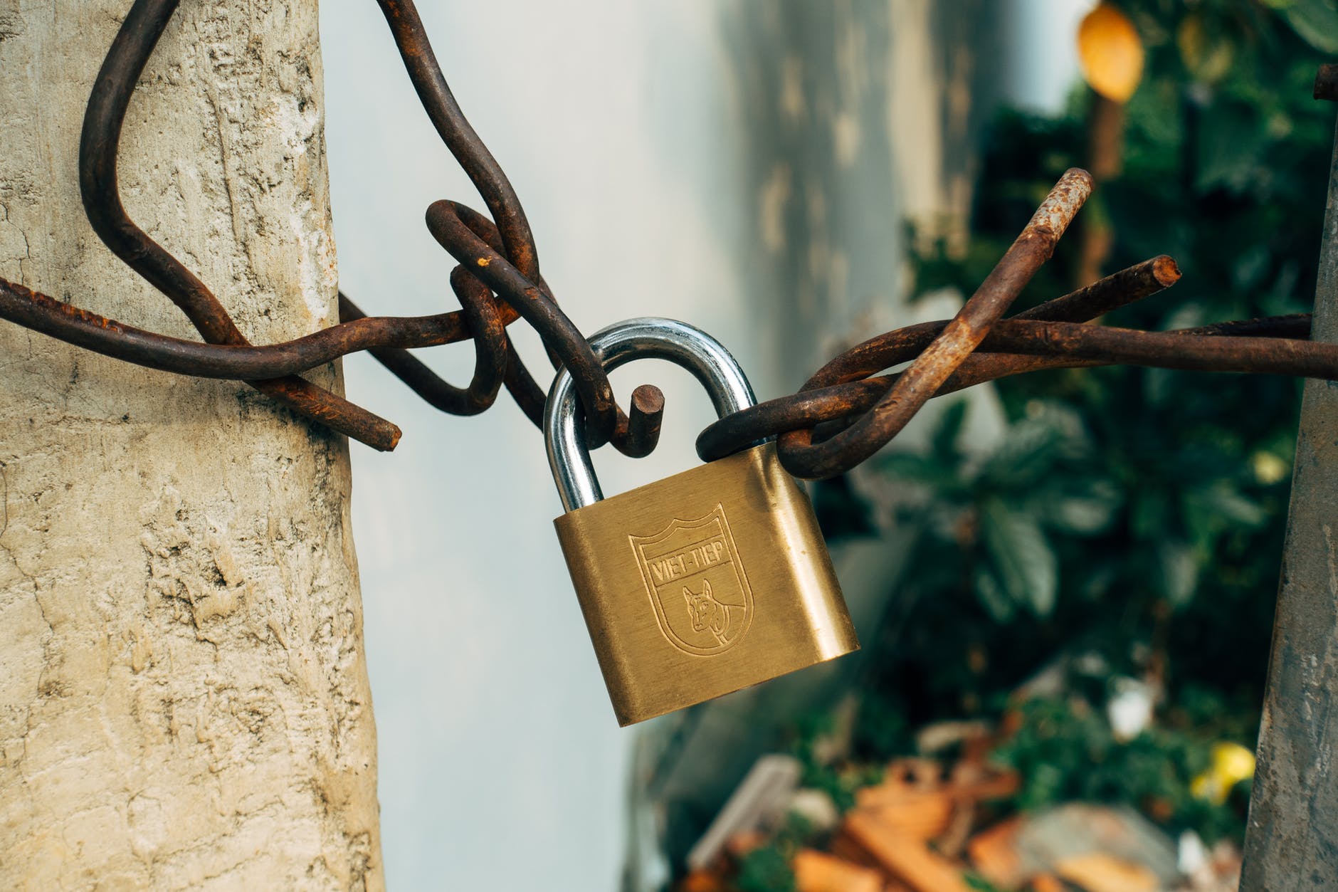 brass padlock on rusty metal wire